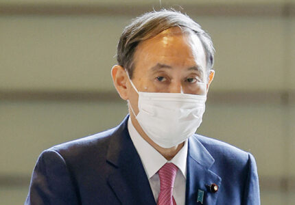 Japanese Prime Minister Yoshihide Suga arrives at his office in Tokyo on Oct. 16, 2020, wearing a mask amid continued worries about the novel coronavirus. (Photo by Kyodo News via Getty Images)